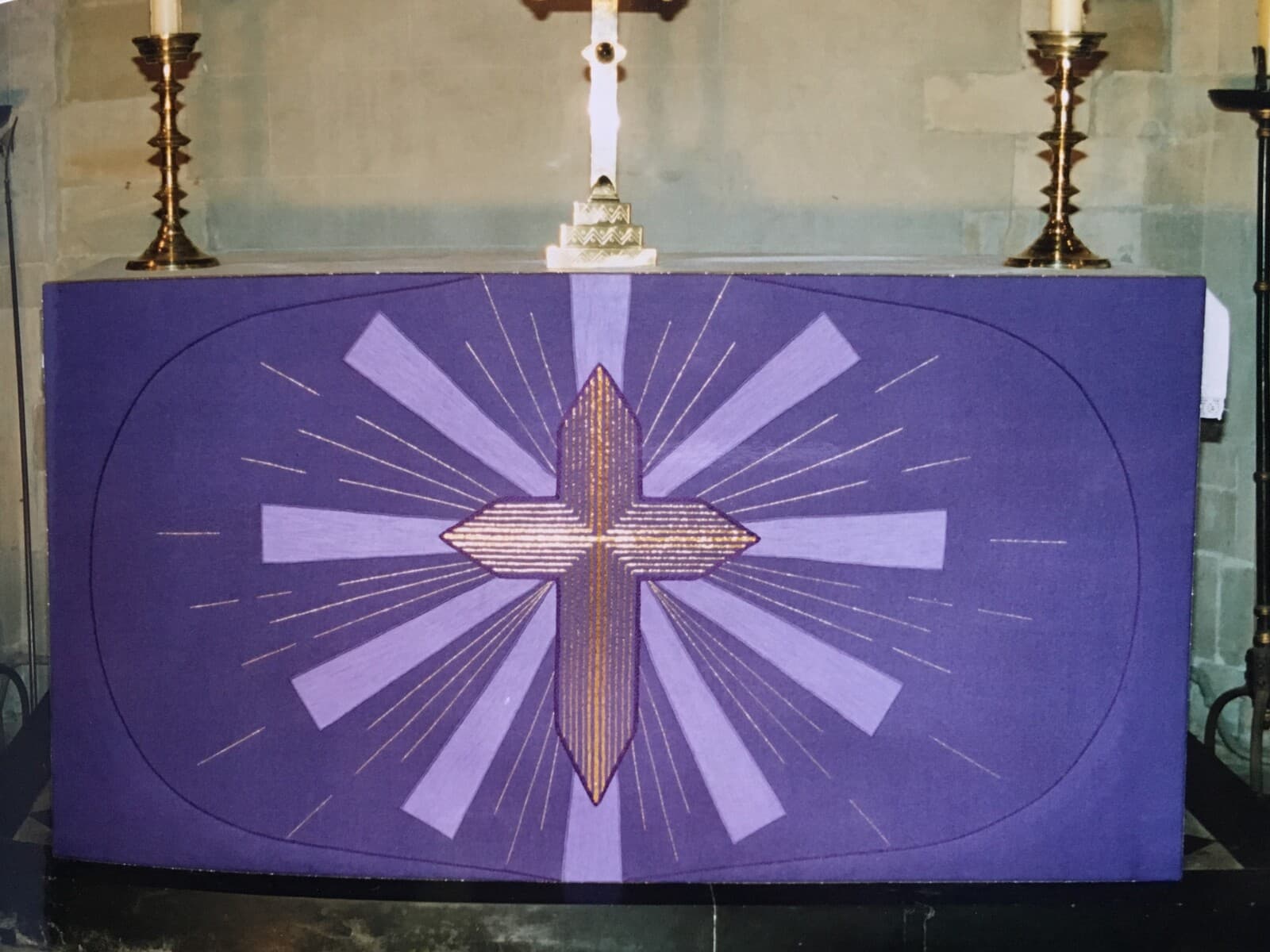 The altar at St James dressed in the purple frontal, with a radiant gold cross at its centre