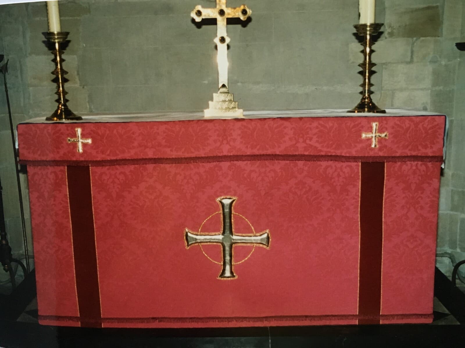 The altar at St James dressed in the red damask frontal with a gold cross at its centre