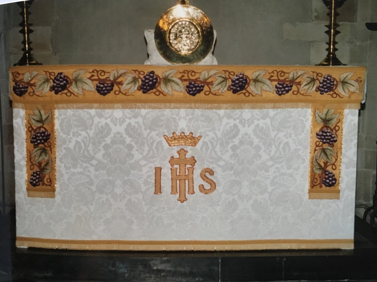 The altar at St James dressed in the white and gold frontal, embroidered with grapes, vine leaves and the IHS monogram beneath a crown