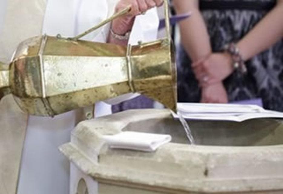 Water poured at the font during a baptism at St James