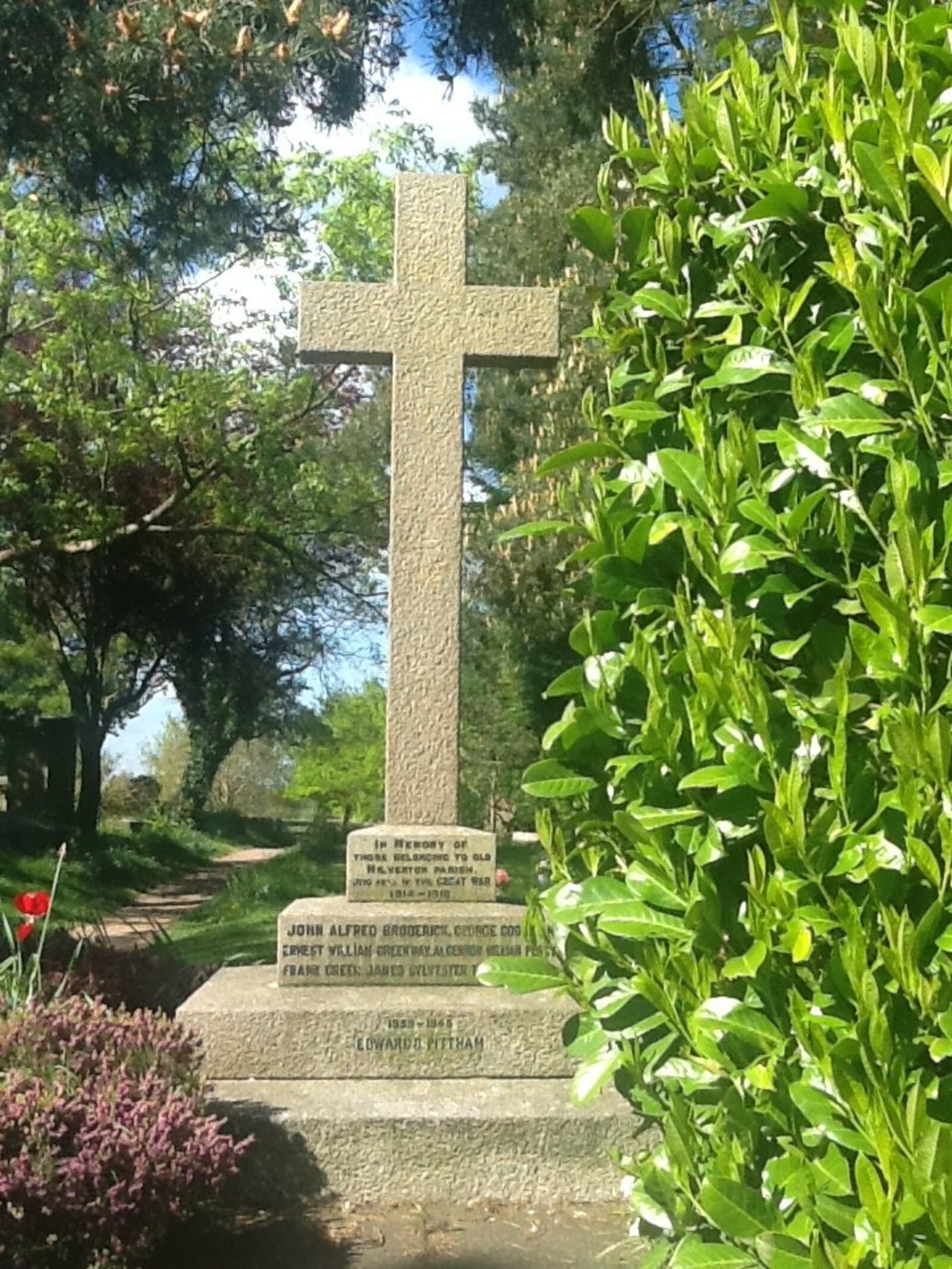 The war memorial cross in St James churchyard, with poppies